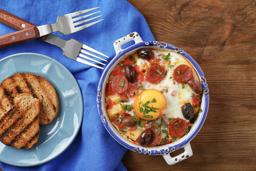 Delicious Spanish baked egg in bowl on kitchen table