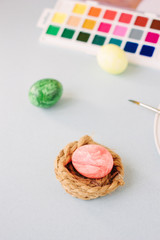 Pink color egg on bright background. Nest and easter.