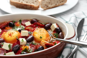 Delicious Spanish baked eggs in baking dish on table, closeup