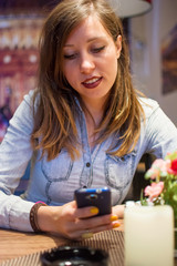 Girl using mobile phone in a restaurant