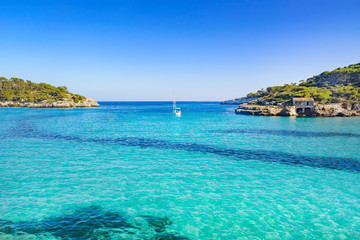 Fototapeta na wymiar Beautiful and calm beach S'Amarador in Mallorca with a boat in the center. This amazing beach is located in the south of Majorca.