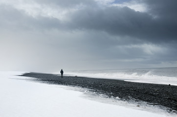 Alone man standing on the dark nordic beach in Iceland - thinking, loneliness concept photo © kovop58