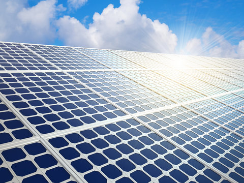 Row of solar energy panels with bright sun reflection flare background.