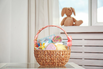 Fototapeta premium Easter basket with sweets and stationery on light background