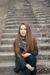 Portrait of a beautiful girl in early spring on the steps