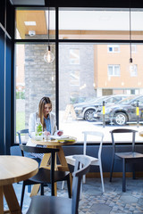 Beautiful Young Woman Sitting in Coffee Shop