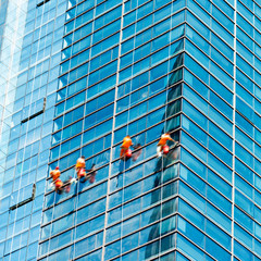 Workers of steeplejack washing windows of the modern building.