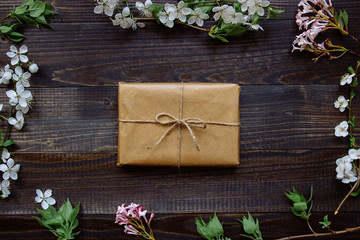 Cute gift box wrapped with craft paper and flowers top view