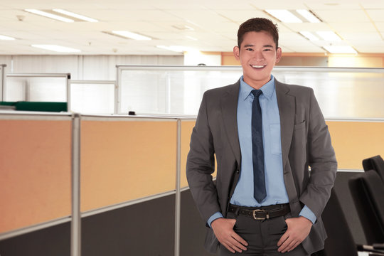 Happy asian businessman standing with relaxed gesture