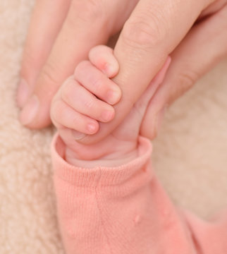 Kleine Hand des Neugeborenes Kindes haltet Zeigefingers des Papas