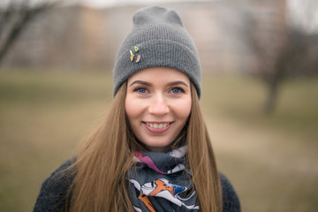Portrait of a beautiful girl in early spring in a gray cap