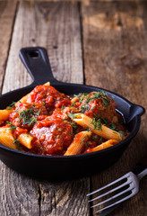 Meatball penne pasta with spicy tomato sauce and dill
