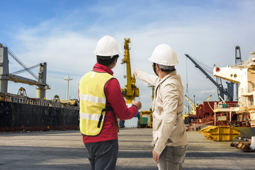 Port and safety controler surveying the port terminal with ship berthing wharf in background