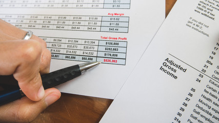 Obraz premium Close up pen at red total summary of profit business report in businness concept.