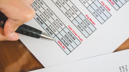 Close up pen at red total summary of  profit business report in businness concept.