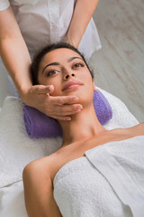 Obraz na płótnie Canvas Woman massagist make face lifting massage in spa wellness center