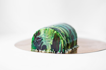  Trendy mousse cake with green mirror glaze decorated. Light background - 143035462