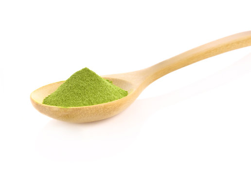 Green tea powder wooden spoon on white background