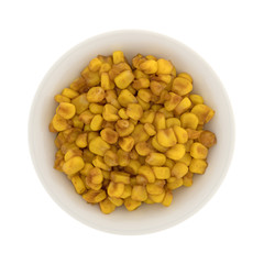Top view of a small bowl of barbecue seasoned corn isolated on a white background.