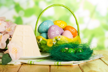 Colored Easter eggs in basket, nest, Easter cheese dessert, flowers.