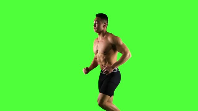 Man running on green screen background, slow motion. Side view