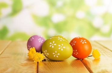 Colorful Easter eggs and florets on abstract green.