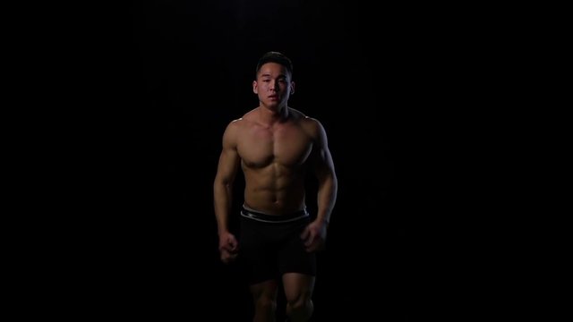 Athlete running on the black background in slow motion. Studio