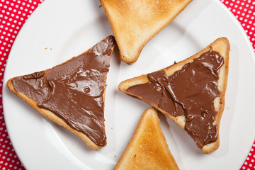 Toast with chocolate on a plate on a red table