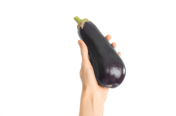 Healthy eating and diet Topic: Human hand holding a ripe eggplant isolated on a white background in the studio, first-person view © Alex