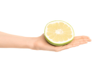 Healthy eating and diet Topic: Human hand holding a half sweetie isolated on white background in the studio