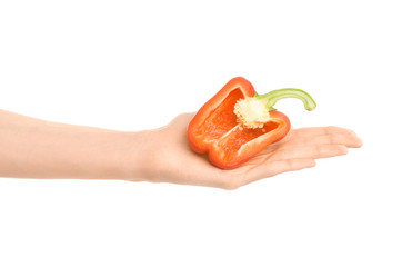 Healthy eating and diet Topic: Human hand holding a half of red pepper isolated on a white background in the studio