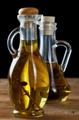 Two bottles of olive oil on rustic table