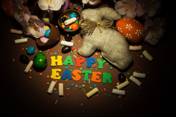 Inscription Happy Easter, Easter Bunny, eggs, sweets and decorations,, flowers.