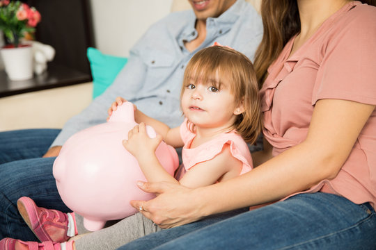 Parents and daughter holding a piggy bank