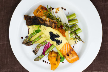 Salmon Fillet With Sauce With Asparagus On White Plate Top View
