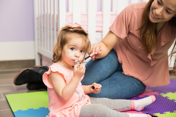 Mother and daughter putting makeup on