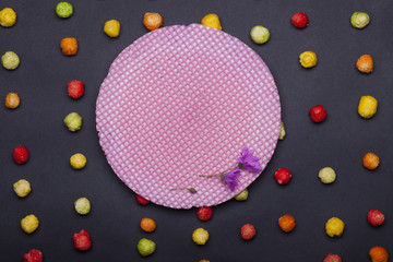 colorful tasty dragee sweets and round pink wafer or waffle