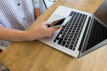 Woman using mobile phone and laptop