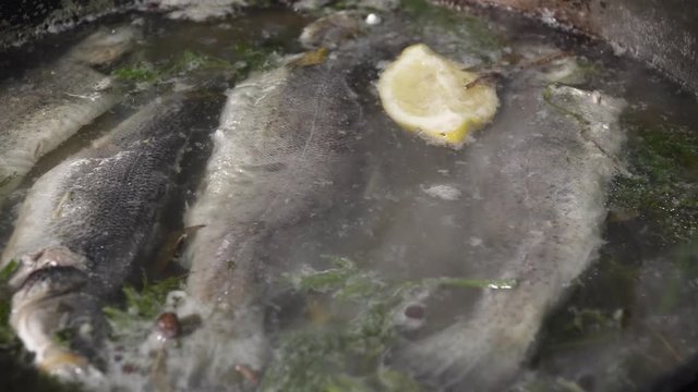 Fish boiled in the frying pan with lemon