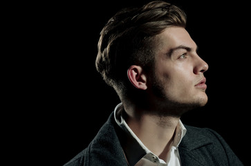 Handsome man with stylish blond hair posing with serious face