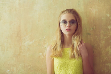 Fototapeta premium Pretty girl with long blonde hair in yellow dress, sunglasses