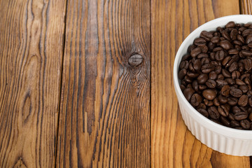 Caffeine. Cropped shot of aromatic coffee beans in a bowl on a wooden table copyspace on the side.