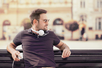 Young attractive man is smiling while wearing headphones