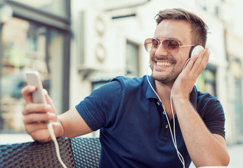 Young attractive man is smiling while wearing headphones