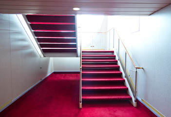 Red carpet on a stairway in a luxury cruise.