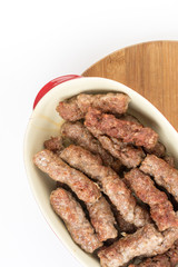Flat lay bowl full of cevapcici kebabs over white background