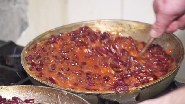 Red kidney beans frying in red sauce in a pan