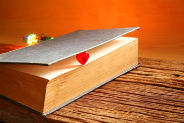 Old book put on the brown color hard wood represent book background concept related idea.