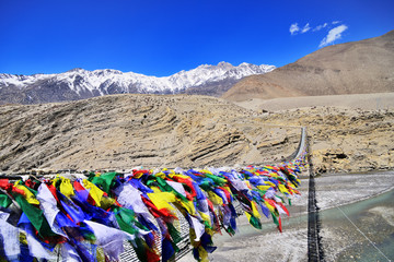 Suspension bridge between Lower Mustang and Upper Mustang with lot of colorful buddhist praying flags, Nepal