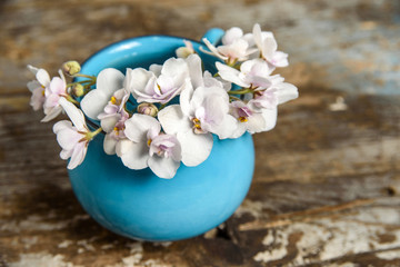 blue mug with spring flowers on wooden background. rustic, shabby chic concept